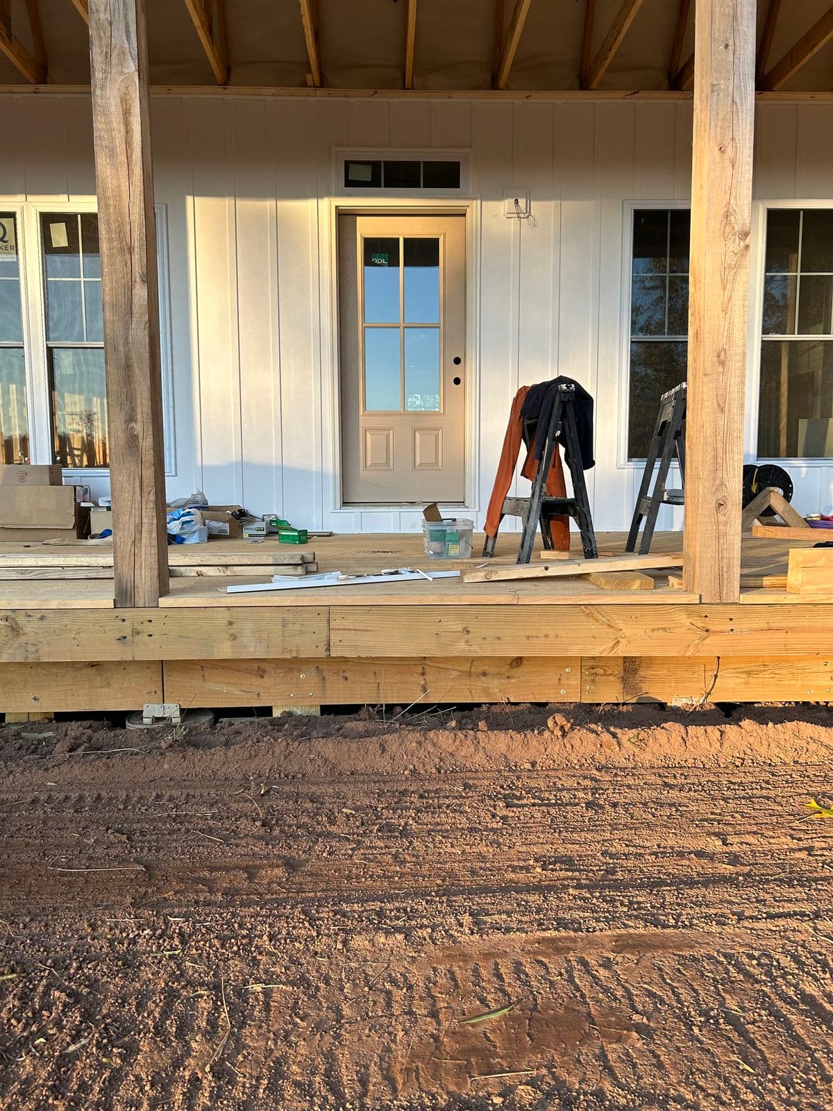 Covered porch with wood posts and a white front door