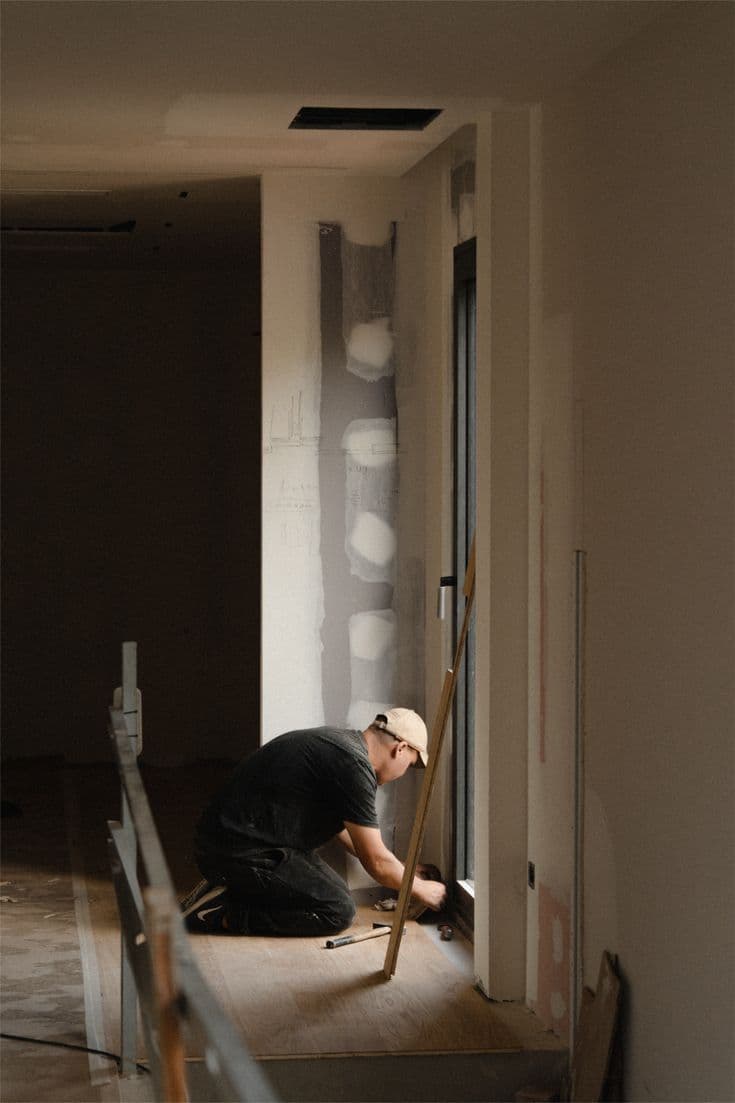 Contractor repairing a wall with a drill